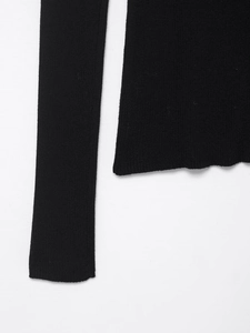 Gros plan détaillé sur la texture en maille côtelée et les coutures du haut noir à manches longues