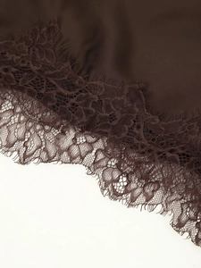 Vue détaillée de l'ourlet de robe en satin marron avec bordure en dentelle cil fine