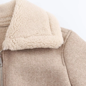 Dettaglio della giacca di lana color cammello con collo in shearling bianco e zip in metallo