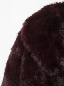 Detail view of the plush burgundy faux fur collar with a soft and luxurious texture