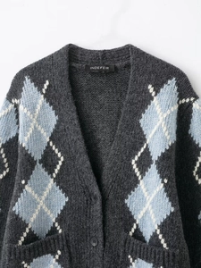Close-up of gray argyle knit cardigan with blue diamonds and textured fabric