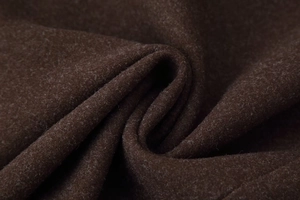Macro shot of dark brown wool coat fabric texture showing soft dense fibers and warm feel