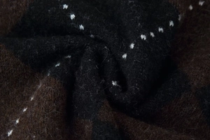 Close-up of thick brown and black geometric knit fabric with a soft wool texture