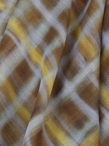 Detailed macro view of plaid fabric texture in brown and yellow watercolor tones