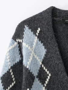 Detailed close-up of thick grey argyle knit cardigan featuring blue and white diamond patterns