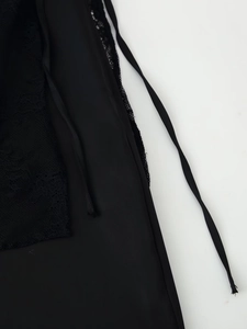 Macro shot of delicate black lace detailing and thin silk straps on women's trousers