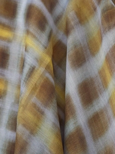 Détail de tissu à carreaux jaune chaud montrant une texture légère et un drapé doux