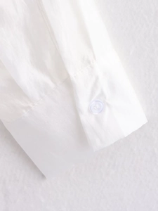 Macro detail of white cotton shirt cuff with button closure and smooth stitching
