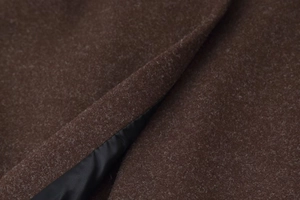 Macro detail of dark brown wool fabric with smooth black lining for winter coat