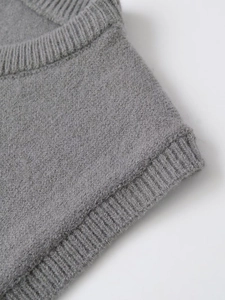 Detail of the grey knitted vest showing high-quality ribbing and fine wool texture