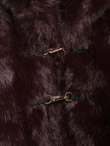 Detail of burgundy faux fur coat showing luxury gold metal hook closures and leather trim