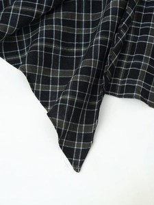 Vue détaillée du tissu à carreaux noir blanc et vert avec texture tissée serrée