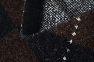 Close-up of knit fabric showing brown and black patterns with textured wool fibers