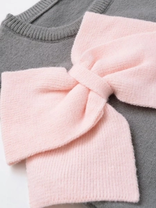 Detailed close-up of gray knit top with soft pink 3D bow and fine rib-knit texture