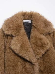 Close-up of brown faux fur texture with detailed brand label and sizing information