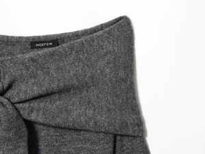 Detail of INDEFEIR brand label on a premium grey knit sweater with fine texture