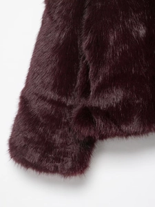 Detailed macro view of burgundy faux fur coat showing soft texture on hem and cuffs