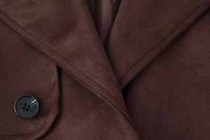 Detail of dark brown wool coat collar showing stitching and marble pattern button
