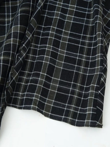 Gros plan détaillé du tissu à carreaux noir et blanc et des coutures de la robe