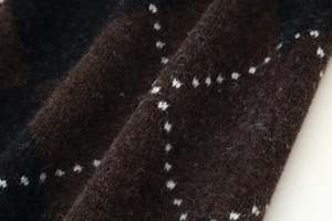 Close-up of knit fabric showing brown and black diamond pattern with soft plush texture