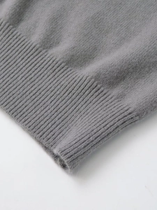 Close-up of gray knit top showing high-quality ribbed hem detail and soft wool texture