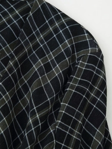 Gros plan sur la texture du tissu à carreaux noir et olive avec tissage détaillé