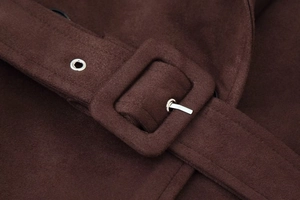 Detailed close-up of dark brown suede coat belt with covered buckle and metal eyelets