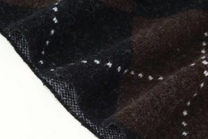 Detailed macro view of soft knit fabric texture with dark brown diamond check pattern