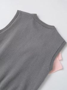 Close-up of knit vest featuring premium ribbed texture and soft fabric in grey and pink