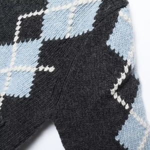 Detailed close-up of argyle knit pattern in dark grey and light blue wool fabric