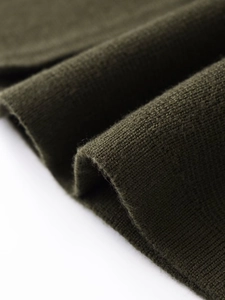 Macro detail of olive green ribbed knit fabric showing texture and soft material quality