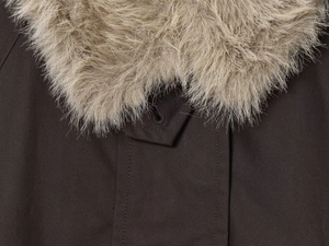 Detailed close-up of brown parka coat featuring a soft beige faux fur collar and stitching