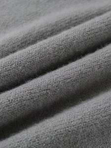 Close-up of soft grey knit fabric texture showing high-quality wool fibers and details