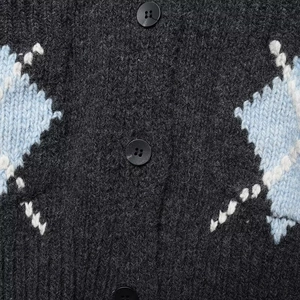 Detail of dark grey knit cardigan with blue argyle pattern and matte black buttons
