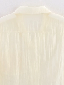 Detailed view of off-white shirt back yoke with delicate pleated texture and fine stitching