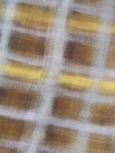 Vue détaillée de la texture du tissu écossais marron et jaune et des fibres tissées