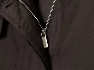 Detail of metal zipper and high-density waterproof fabric on the dark brown parka coat
