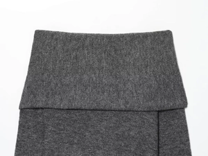 Close-up detail of dark grey knit fabric texture showing the wide folded waistband design