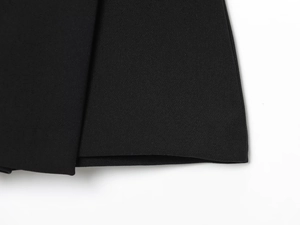 Détail de l'ourlet lisse et de la texture du tissu tissé du short-jupe noir plissé