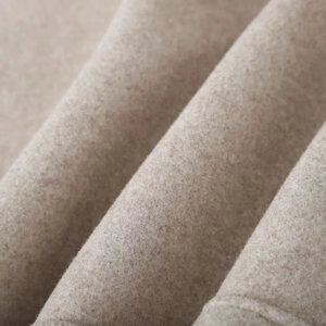 Close-up detail of soft beige wool blend fabric texture on the stylish women jacket