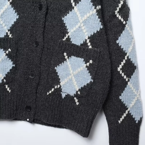 Detailed macro view of diamond pattern jacquard knit cardigan with ribbed cuffs and buttons