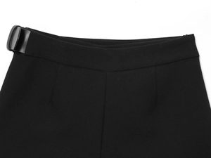 Détail du pantalon noir à taille haute avec boucle de réglage latérale minimaliste
