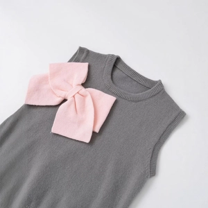 Sleeveless grey knit vest for women with a contrasting pink bow decoration on front