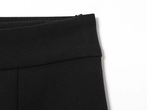 Vue détaillée du short plissé noir avec fermeture éclair invisible et coutures de précision