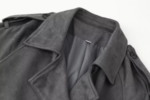 Detail of dark grey suede coat featuring lapel structure and shoulder epaulettes button