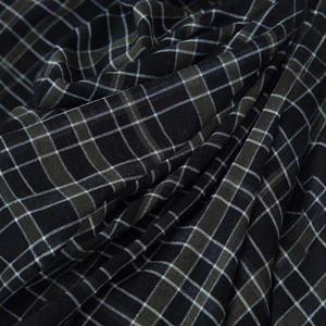 Gros plan détaillé du tissu à carreaux noir et gris avec une texture plissée douce et motifs