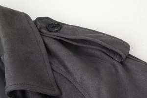 Macro shot of charcoal grey wool coat shoulder strap detail with black button
