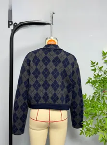 Close-up of navy and gray argyle knit cardigan with V-neck collar and ribbed cuffs