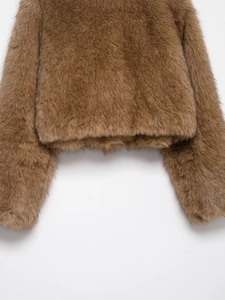 Detail showing the thick brown faux fur texture and glossy finish of the cropped jacket