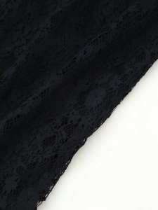Macro shot of elegant black lace dress fabric with delicate floral hollow patterns